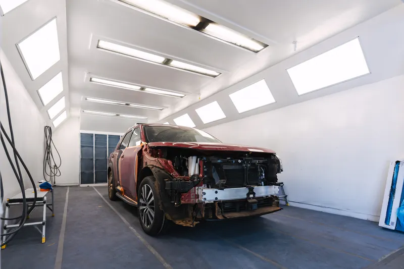 A vehicle masked and staged inside the paint booth